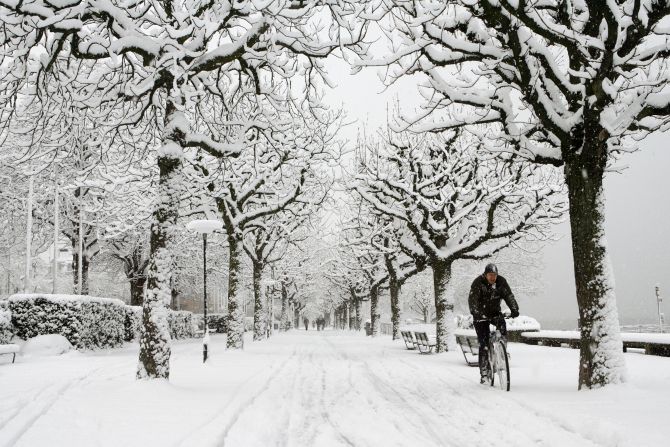 A man cycles during snowfall in Zurich.