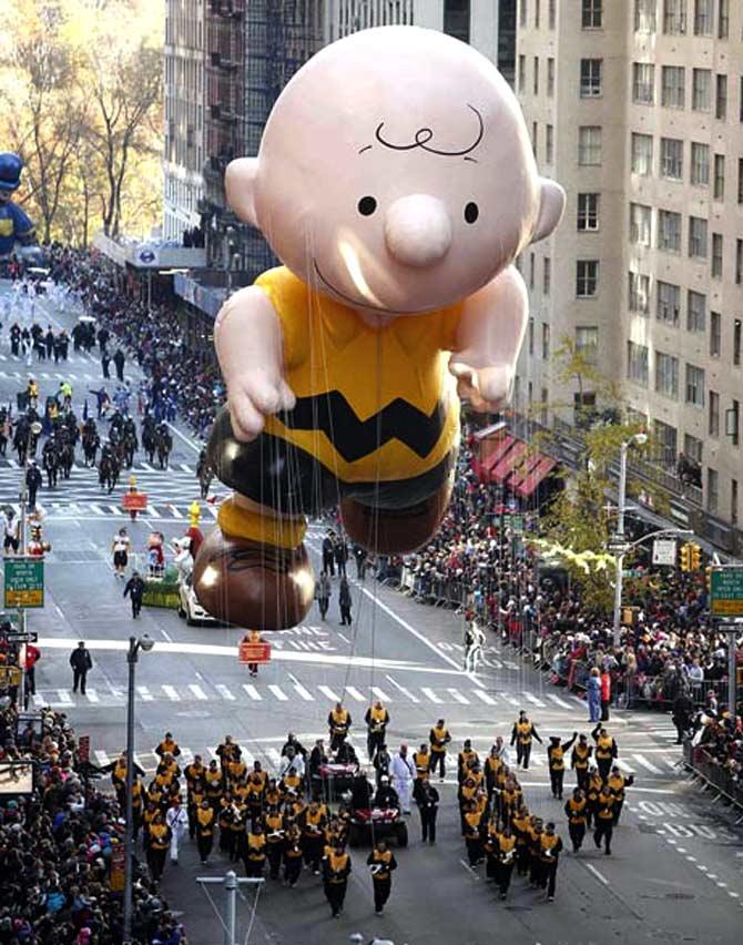 A Charlie Brown balloon floats make their way down 6th Ave during the Macy's Thanksgiving Day Parade in New York.