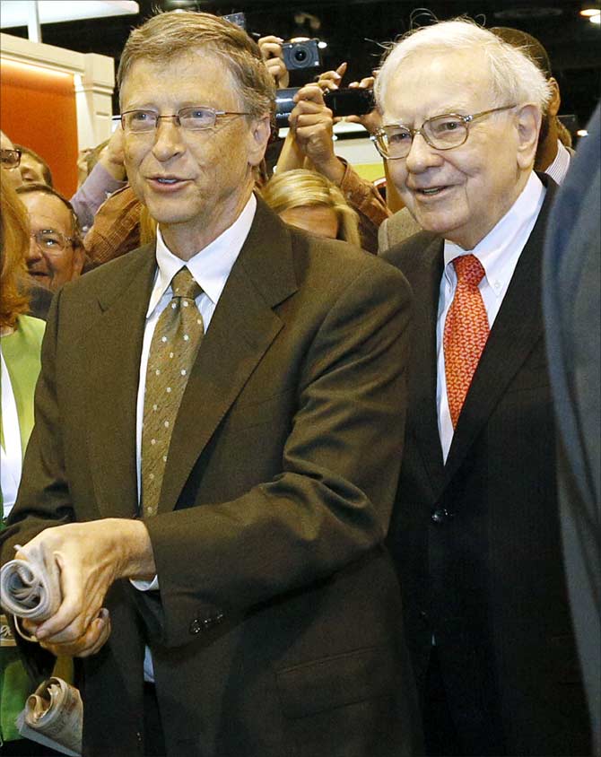 Berkshire Hathaway CEO Warren Buffett (R) watches Microsoft Chairman Bill Gates prepare to throw a newspaper in a competition just before Berkshire Hathaway's annual meeting in Omaha.