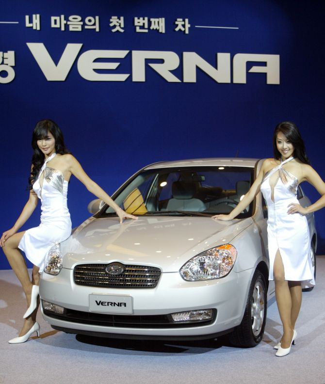 South Korean models pose next to Hyundai Motors' New Verna at its unveiling ceremony in Seoul.