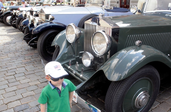 A boy walks past vintage Rolls-Royce cars during the 20-Ghost Club Nordic and Baltic tour in Riga.