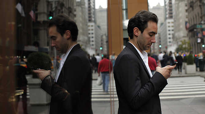 A man types on his mobile phone outside of the Trump Tower in New York City.