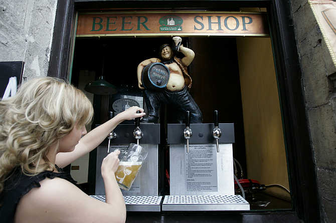A waitress pours a pint of beer during the annual Belgian beer weekend at the Grand Place in Brussels, Belgium.