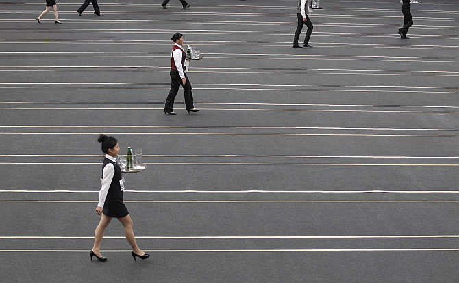 Contestants race with trays containing beer bottles and glasses during the Wowprime tray carrying competition in Taipei, Taiwan.