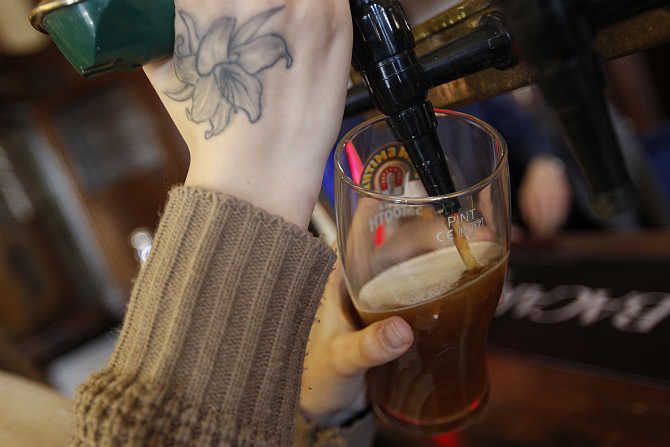 A barmaid pours a pint of beer at The Builders Arms pub in east London.