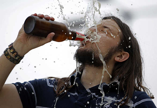A man drinks a beer during during a wrestling show in Budapest, Hungary.