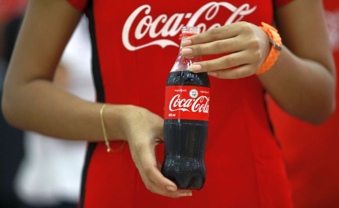 A promotion lady holds a new 425 ml (14 oz) Coca-Cola bottle during an event to introduce the new packaging at a shopping mall in Yangon.