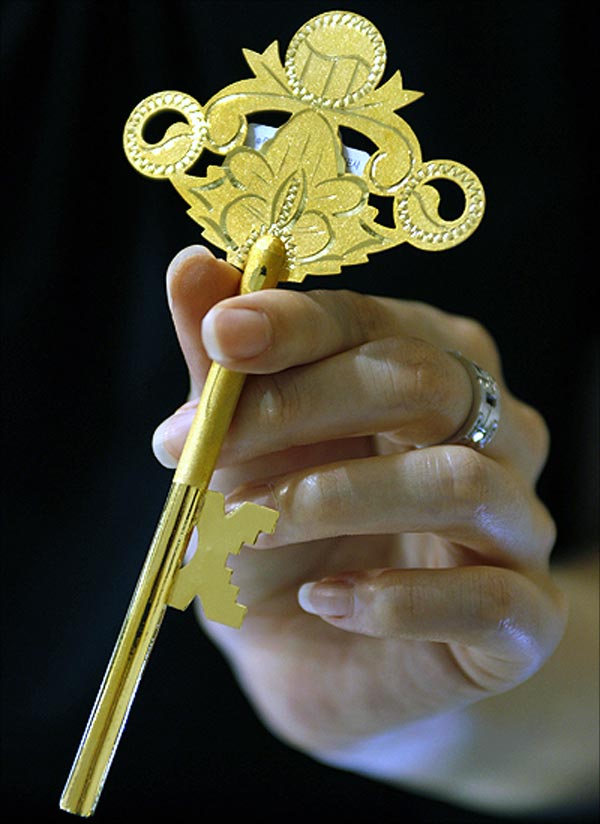 An employee holds a gold key at a jewellery shop.