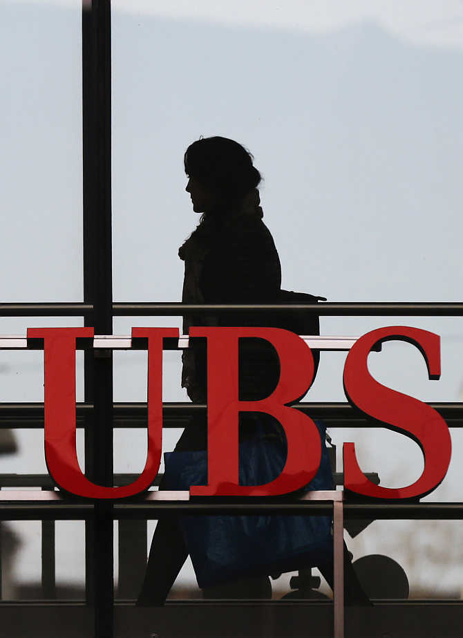 An employee walks past a logo of Swiss bank UBS in Zurich, Switzerland.