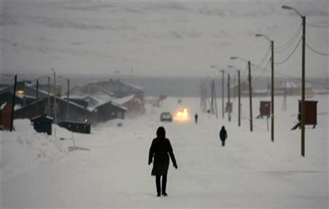 Pedestrians walk down the main street in the arctic town of Longyearbyen.