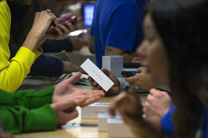 Customers purchase the iPhone 5s at the Apple retail store on Fifth Avenue in Manhattan, New York.