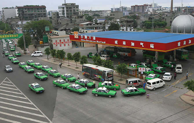 Taxis wait to fill their tanks at a petrol pump in Suining, Sichuan province, China.
