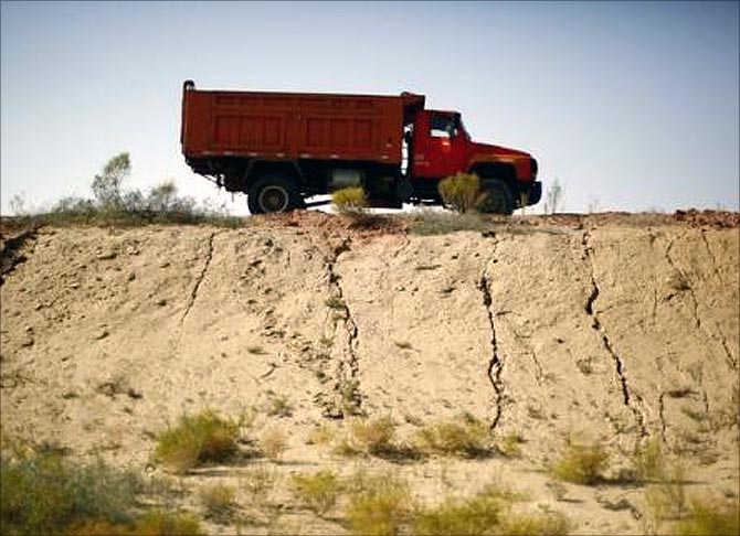A truck drives along a road near the dried up Shiyang river on the outskirts of Minqin town, Gansu province.