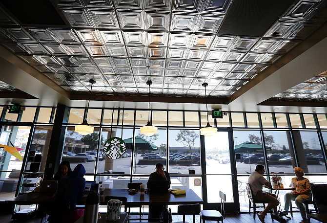 Customers enjoy their drinks inside a Starbucks coffee shop in Fountain Valley, California.