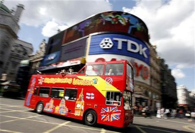 A sightseeing bus passes through London's Piccadilly Circus.