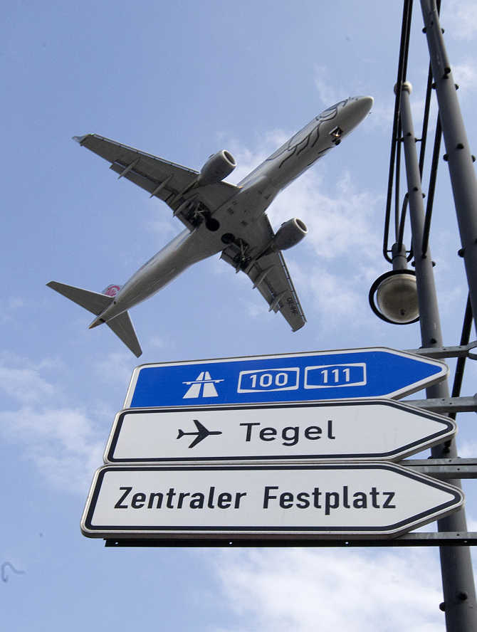 A plane flies above a traffic sign as it approaches Berlin's Tegel airport for landing in Germany.