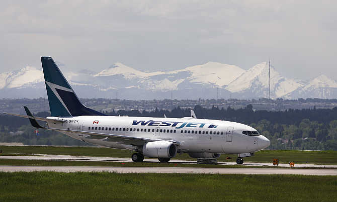 A Westjet airline plane lands at the Calgary International Airport in Calgary, Alberta, Canada.
