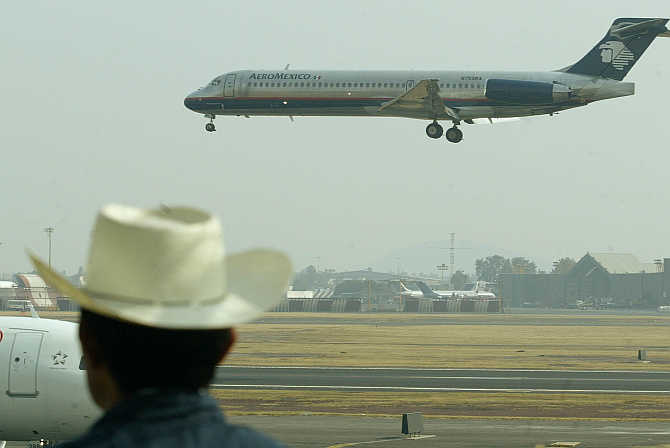A plane spotter watches an Aeromexico aircraft land at Mexico City's international airport, Mexico.