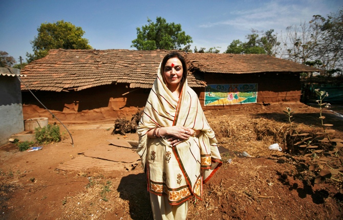 Nita Ambani poses in front of a hut during a 'Reliance Bij - Bharat India Jodo' campaign at Salarpur village, south of Ahmedabad.