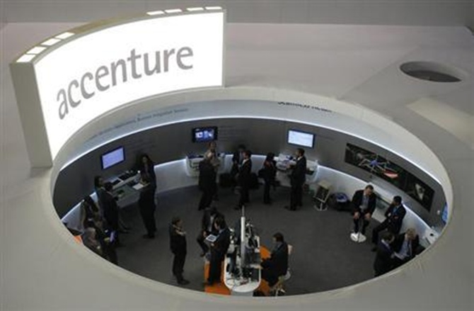 Visitors look at devices at Accenture stand at the Mobile World Congress in Barcelona.