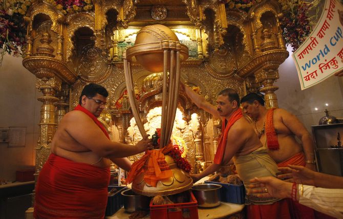 Hindu priests hold a replica of the Cricket World Cup trophy during a puja, or blessing ceremony, at the Siddhivinayak temple in Mumbai.