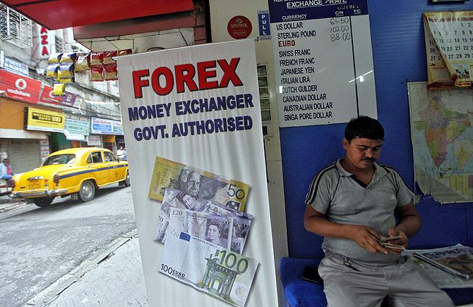 A customer counts currency inside a currency exchange shop in Kolkata.