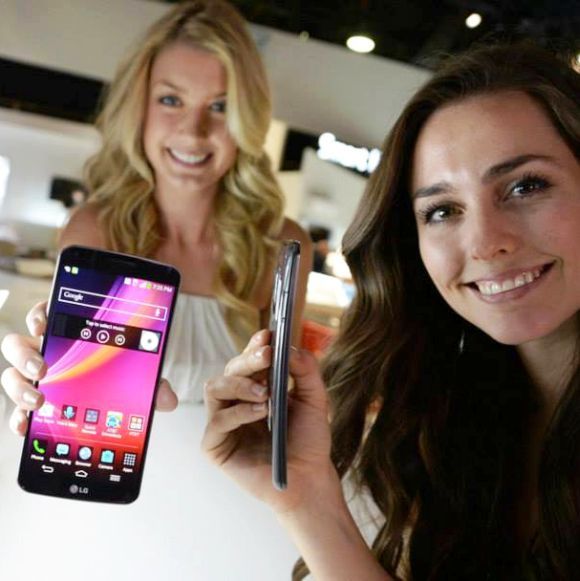 Models hold LG G Flex smartphone.