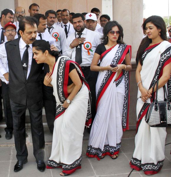 Sahara Group Chairman Subrata Roy (front, L) speaks with an employee.