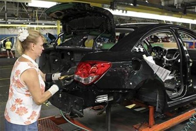Image: A worker installs the rear tail light assembly on the new Chevrolet Cruze car as it moves along the assembly line at the General Motors Cruze assembly plant in Lordstown, Ohio. Photograph: Aaron Josefczyk/Reuters