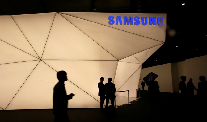 Visitors walk past the Samsung stand at the Mobile World Congress in Barcelona February 24, 2014.