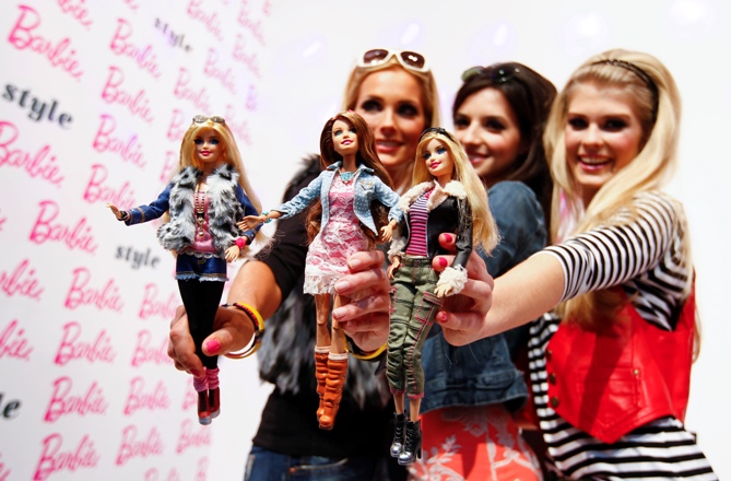 Models pose with the popular 'Barbie' doll during the press preview of the 65th International Toy Fair in Nuremberg January 28, 2014. 