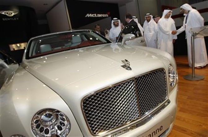 Dubai's deputy ruler Sheikh Maktoum bin Mohammed bin Rashid al-Maktoum (3rd L) tours Bentley's display with other officials at the Dubai International Motor Show.
