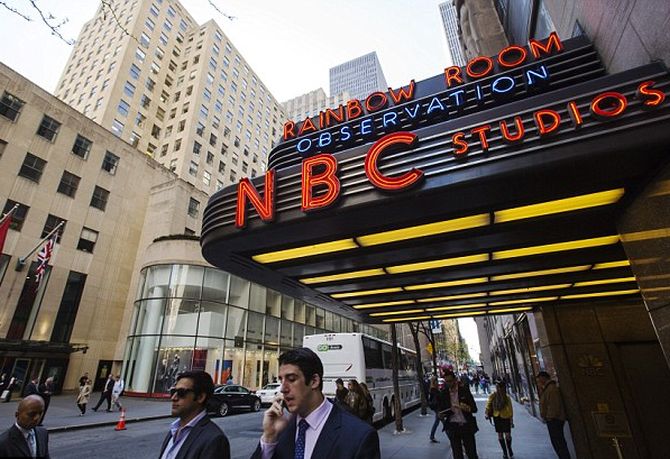 Pedestrians walk past the entrance to the NBC studios, outside Rockefeller Center.