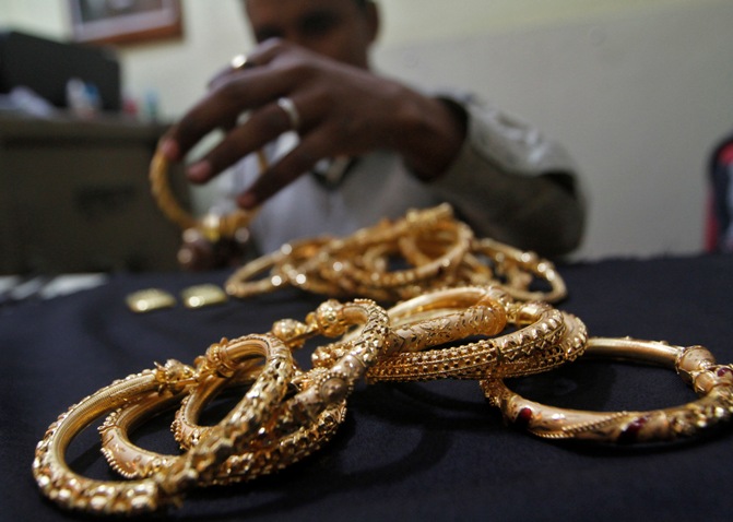 A goldsmith holds finished gold bangles at a workshop in Kolkata.