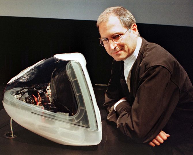 Steve Jobs standing next to the iMAC DV Special Edition that is encased in a clear graphite colour.