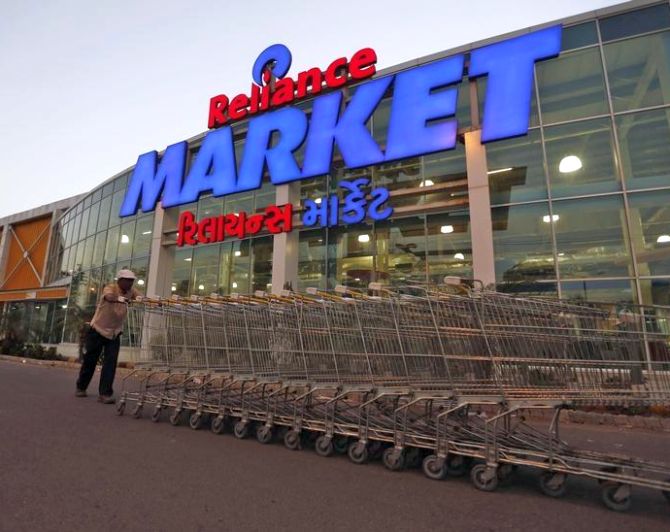 A worker pushes trolleys outside the Reliance Market superstore in the western Indian city of Ahmedabad.