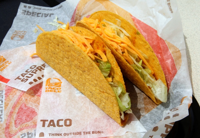 Two crunchy tacos are pictured at a Taco Bell restaurant.