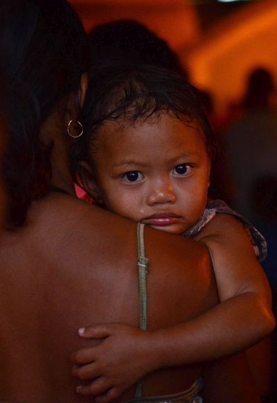 A young girl with her mother attend a religious mass at a local chapel following a super typhoon.