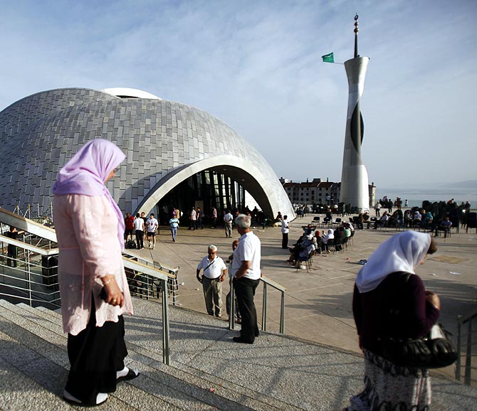 Muslims walk near a mosque.