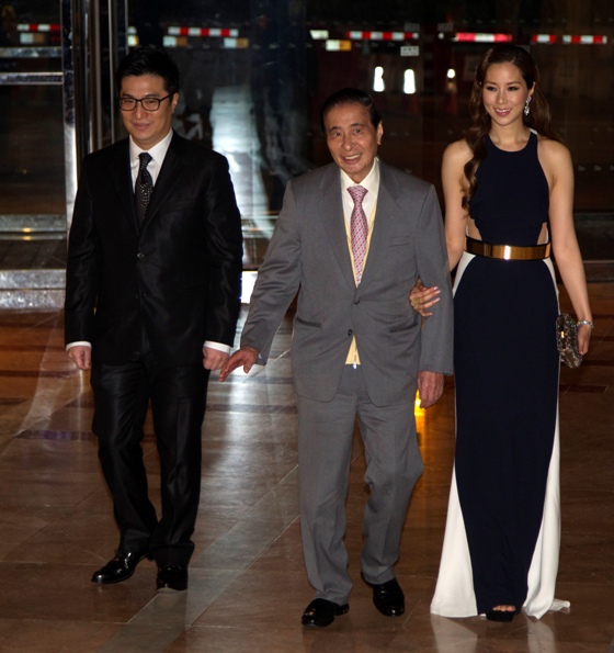 Hong Kong tycoon Lee Shau Kee (C), Martin Lee Ka-Shing (L) and his wife Cathy Chui attend a wedding ceremony.