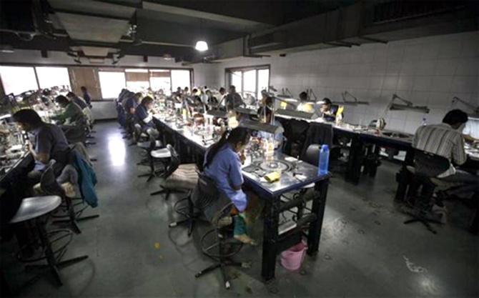 Employees work inside the polishing department of a diamond processing unit at Surat.