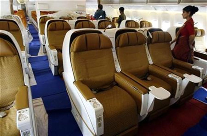 People walk inside the business class section of Air India's Boeing 777-200 LR aircraft.