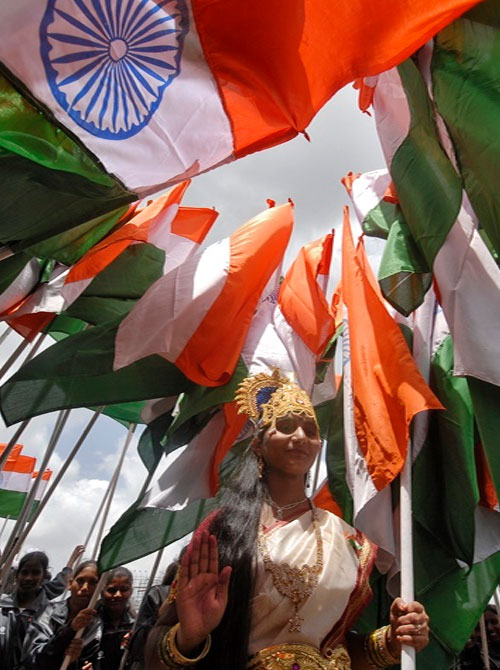 A woman dressed as Mother India poses with India's national flags during the country's Independence Day celebrations in Hyderabad. 