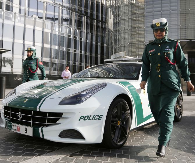 Police officer Badrya Salem AlSowaidi walks near a Ferrari police car.