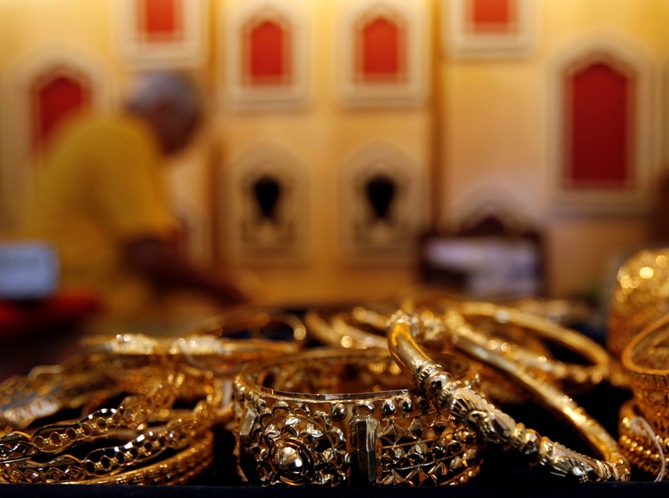 A gold jewellery shop owner arranges ornaments at a counter in Kolkata.
