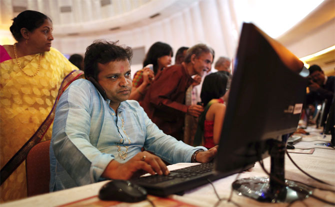 A stockbroker speaks on phone while trading at a terminal during the Diwali special trading session.