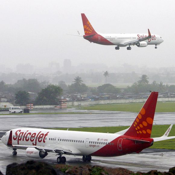 India's SpiceJet aircrafts prepare for landing and take-off at the airport in Mumbai.