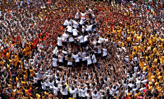Devotees try to form a human pyramid to break a clay pot containing curd during the celebrations to mark Janmashtami in Mumbai August 18, 2014.