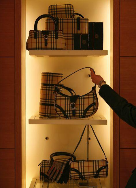 A salesgirl takes a handbag at a store.