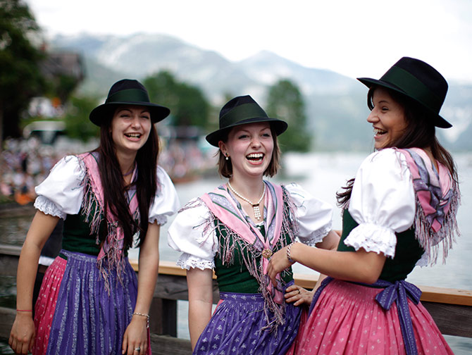 Women in traditional Dirndl dresses watch a boat parade during Narzissenfest (Daffodil Festival) at Grundlsee lake in the village of Grundlsee.